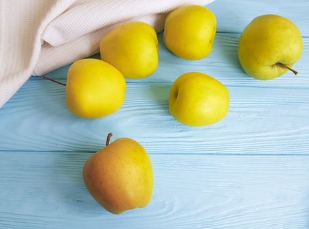 yellow apples on a blue wooden towel backgroundの写真素材