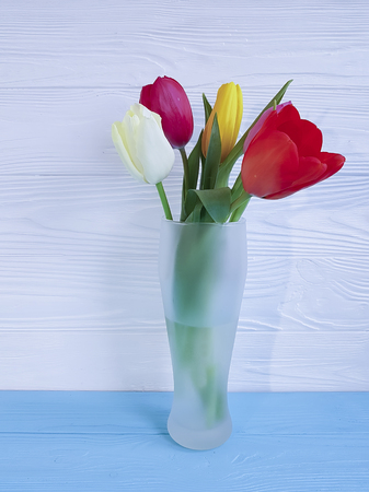 Beautiful bouquet of tulips on white wooden, vase with place for textの写真素材