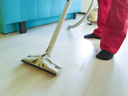 man vacuuming the floor in the room, cleaning serviceの写真素材