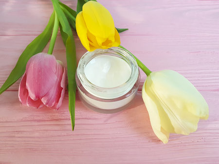 cosmetic cream with tulip on pink woodenの写真素材