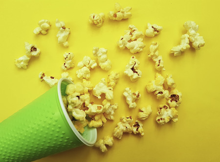 popcorn in a glass on a green backgroundの写真素材