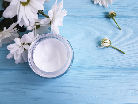 cosmetic cream white flowers blue wooden backgroundの写真素材