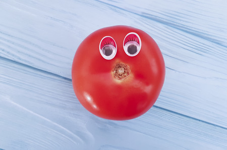tomato cartoon on blue woodenの写真素材