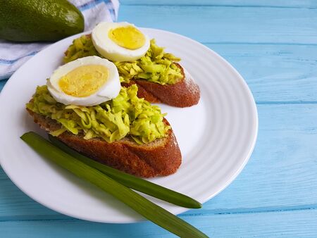 sandwich with avocado egg on blue