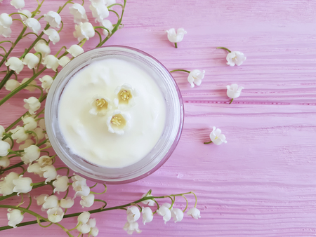 cream cosmetic flower lily of the valley on a pink wooden backgroundの写真素材