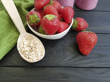oatmeal strawberry smoothies on a black wooden backgroundの写真素材