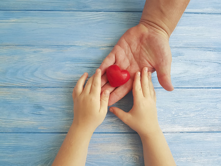 Father's Day Hands Dad and Child's Heart on a Blue Wooden Backgroundの写真素材