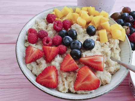 oatmeal, strawberry, raspberry apricot blueberry yogurt on a blue wooden backgroundの写真素材