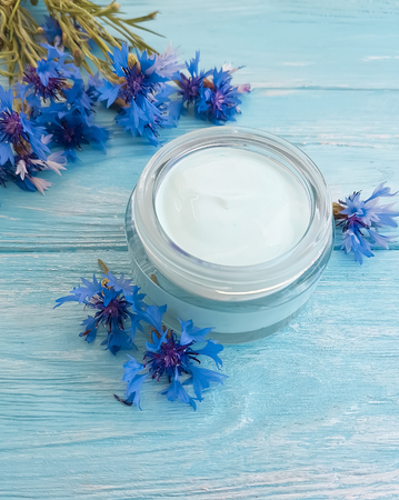 cream cosmetic flowers cornflower on a wooden backgroundの写真素材