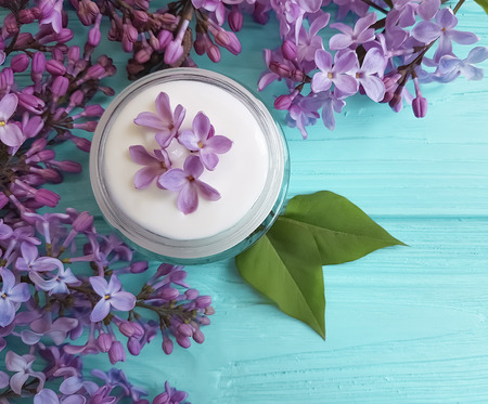 cream cosmetic lilac flower on a blue wooden backgroundの写真素材