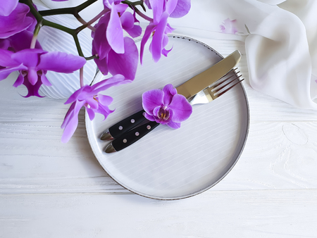 plate of fork knife flower orchid on white wooden backgroundの写真素材
