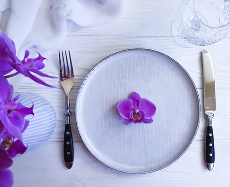 plate of fork knife flower orchid on white wooden backgroundの写真素材