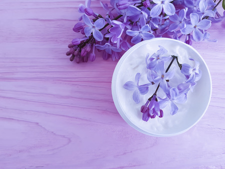 cream cosmetic flower lilac on a wooden backgroundの写真素材