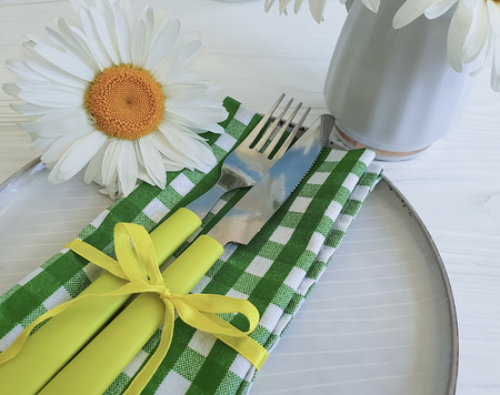 plate, fork, knife daisy on wooden background