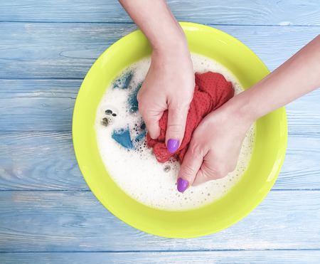 hands washing clothes in a basinの写真素材