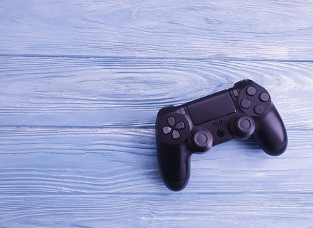 black game controller on wooden background