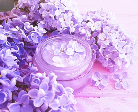 cosmetic cream, lilac flower on wooden backgroundの写真素材