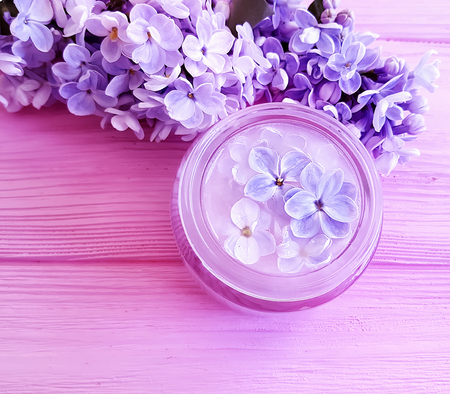 cosmetic cream, lilac flower on wooden backgroundの写真素材