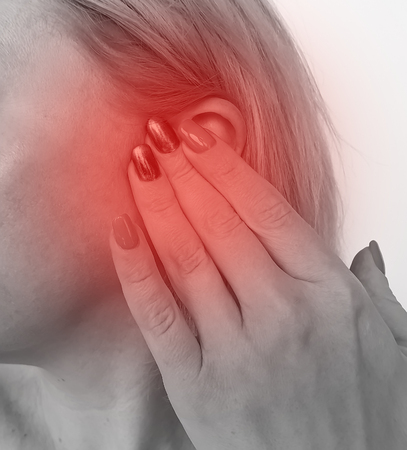 woman hurts ear hearing loss