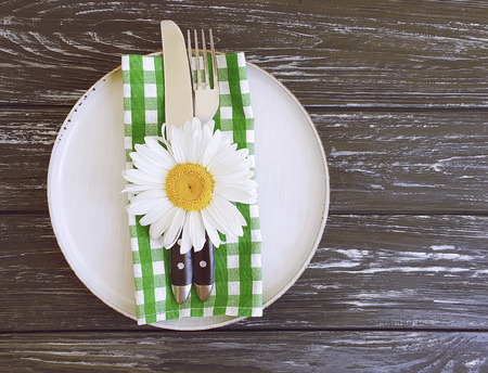 plate, daisy flower on wooden background diningの写真素材