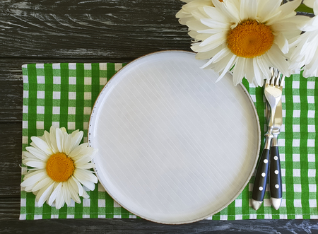 plate, daisy flower on wooden background diningの写真素材