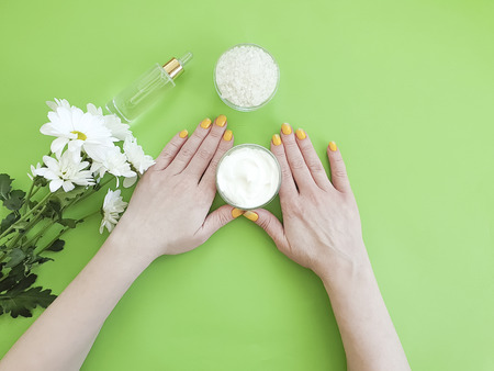 female hands manicure, cream cosmetic flower chrysanthemumの写真素材