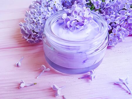 cream cosmetic lilac flower on woodenの写真素材