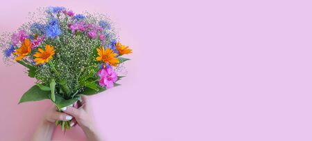female hand holding a bouquet of summer flowersの写真素材