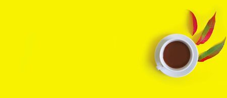 cup of coffee autumn leaves on a coloredの写真素材