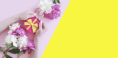 female hands holding a gift box a peony flowerの写真素材