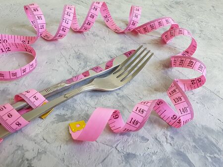 fork knife centimeter tape on concrete backgroundの写真素材