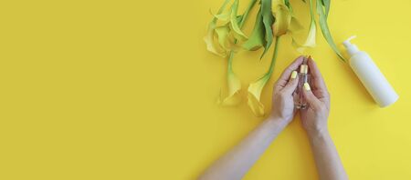 cosmetic cream, female hands, calla flower on a colored backgroundの写真素材