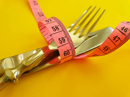 fork knife measuring tape on colored background