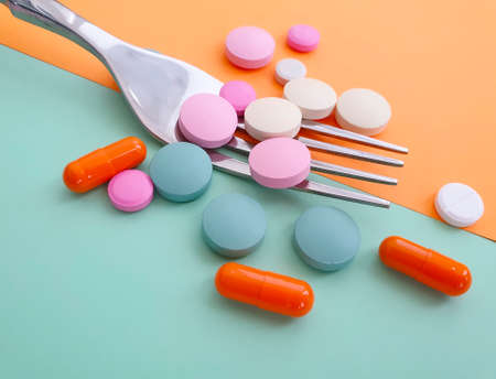 pills fork on colored background capsule, conceptの写真素材
