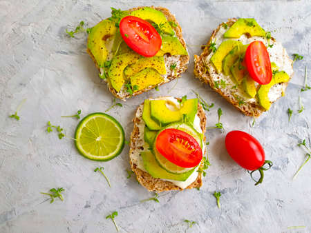 avocado sandwich on concrete background, tomato