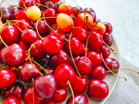 ripe cherries in a plate on concrete backgroundの写真素材