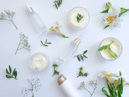 cosmetic cream, flower on light background