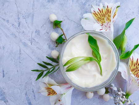 cosmetic cream, flower on a concrete background
