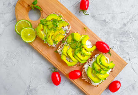 avocado sandwich, tomato on concrete background