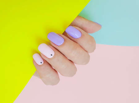female hand beautiful manicure on a colored background