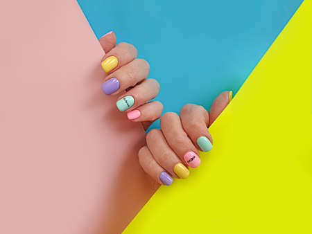 female hand beautiful manicure on a colored backgroundの写真素材