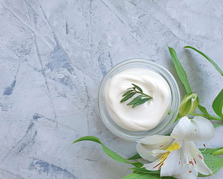 cosmetic cream, flower on a concrete background