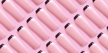 bottle of shampoo and balm on a colored pink backgroundの写真素材