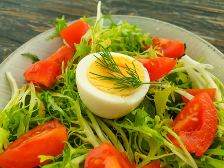 salad with herbs, tomatoes on a wooden backgroundの写真素材