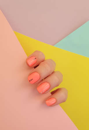 female hand beautiful manicure on a colored backgroundの写真素材