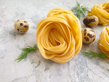 raw pasta, quail egg on a concrete backgroundの写真素材