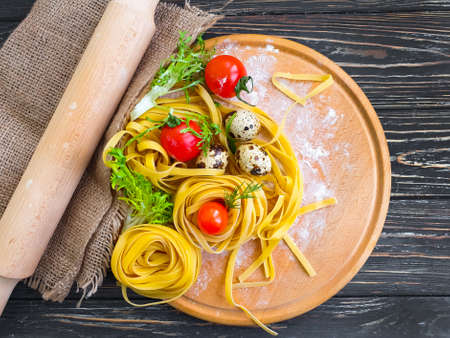 raw pasta, quail egg on a wooden backgroundの写真素材