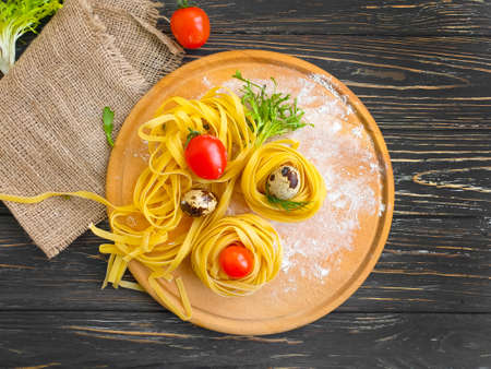 raw pasta, quail egg on a wooden backgroundの写真素材