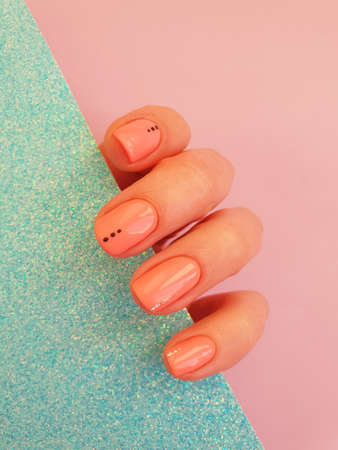 female hand beautiful manicure on a colored backgroundの写真素材