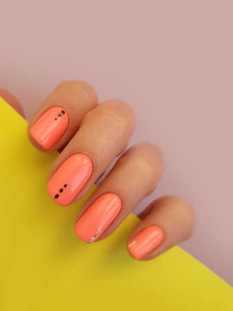 female hand beautiful manicure on a colored backgroundの写真素材